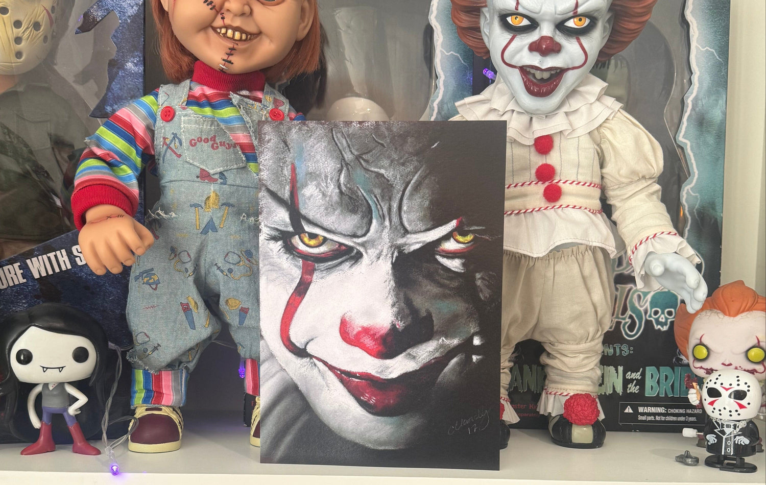 Collection of horror-themed action figures and movie posters on a shelf.